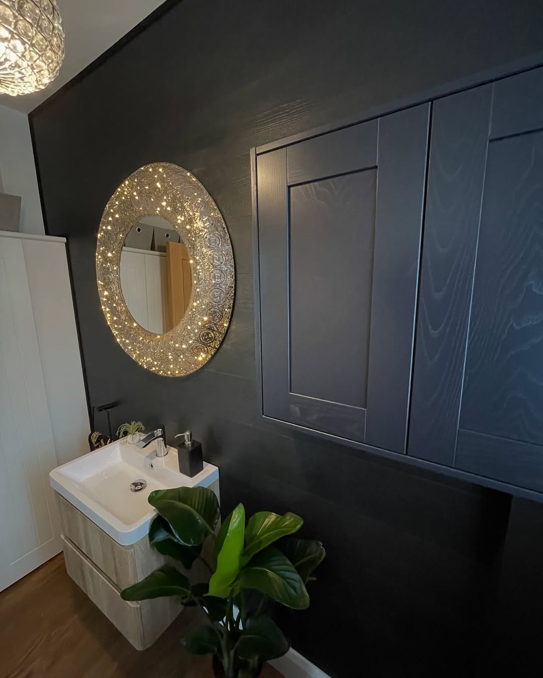 High-end bathroom interior finish by deevelop Heswall — dark panelled cabinetry and feature mirror
